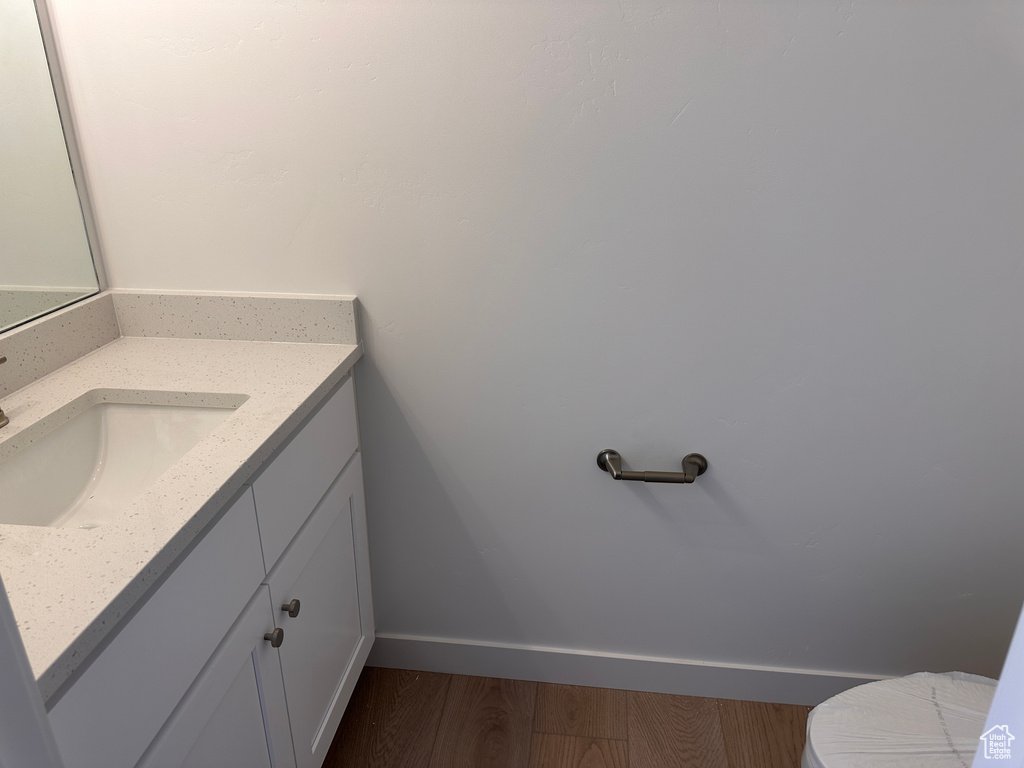 Bathroom featuring vanity, toilet, and wood-type flooring