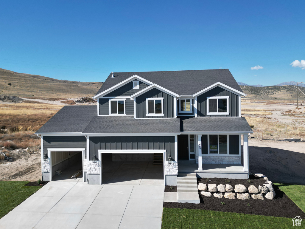 View of front of house with a porch, a mountain view, and a garage