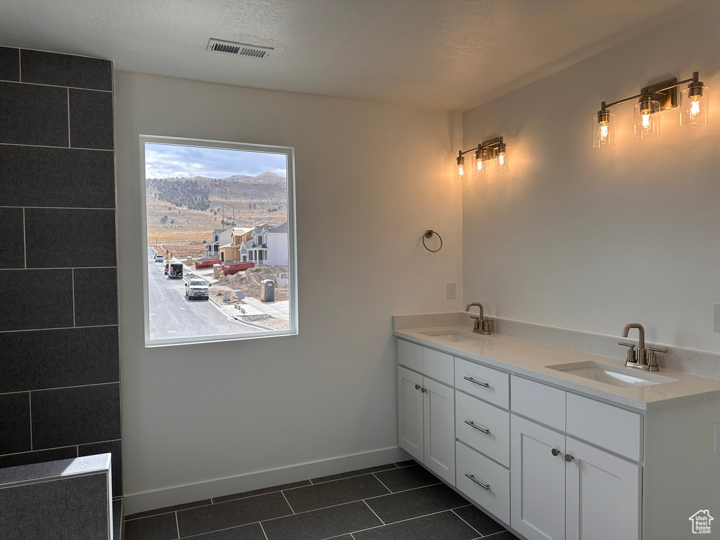 Bathroom with tile patterned floors, vanity, and a textured ceiling