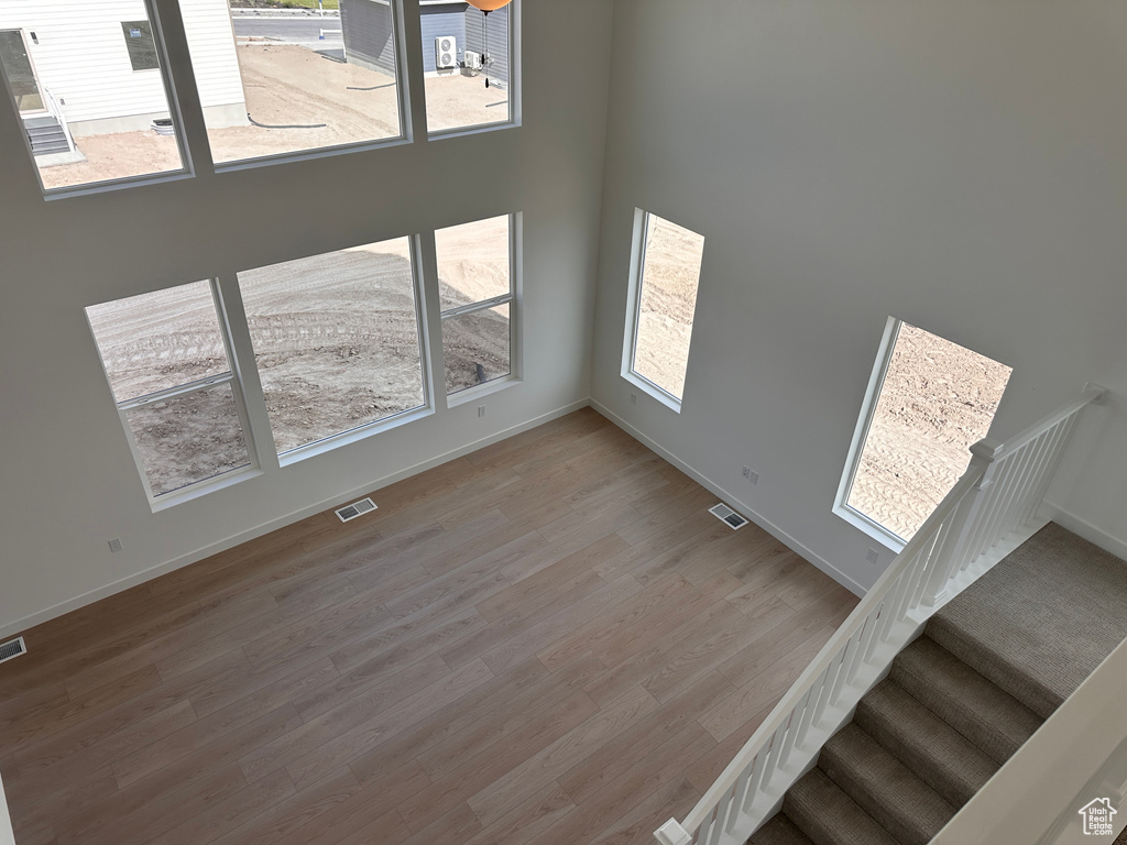 Unfurnished living room featuring a healthy amount of sunlight and hardwood / wood-style floors