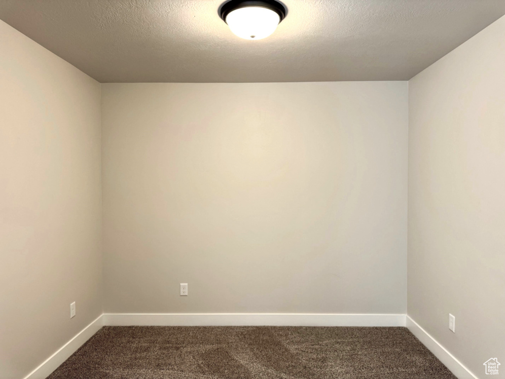 Carpeted empty room featuring a textured ceiling