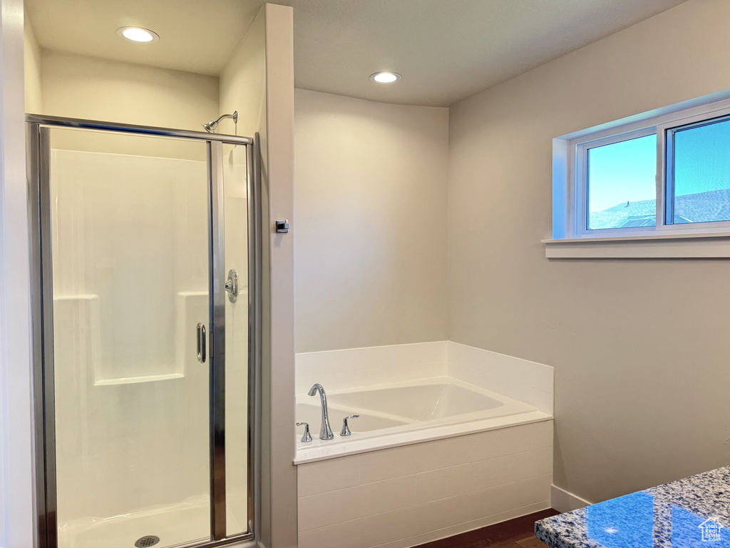 Bathroom featuring shower with separate bathtub and hardwood / wood-style floors