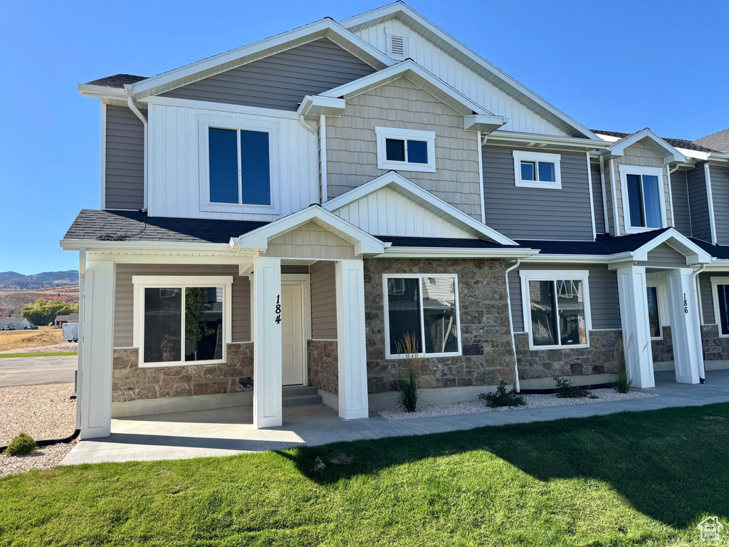 Craftsman-style home with covered porch and a front yard