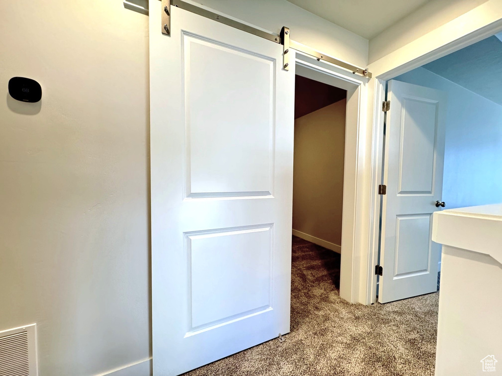 Corridor featuring carpet floors and a barn door