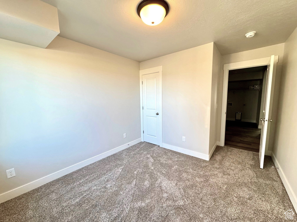 Unfurnished bedroom with a textured ceiling and carpet flooring