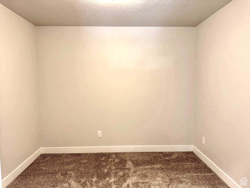 Carpeted empty room featuring a textured ceiling