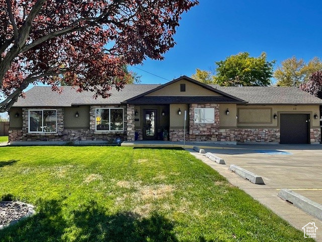 Single story home with a garage and a front lawn