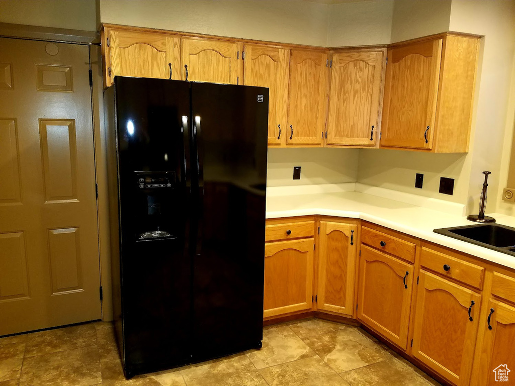 Kitchen with sink and black fridge with ice dispenser