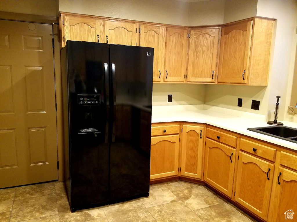 Kitchen with black refrigerator with ice dispenser