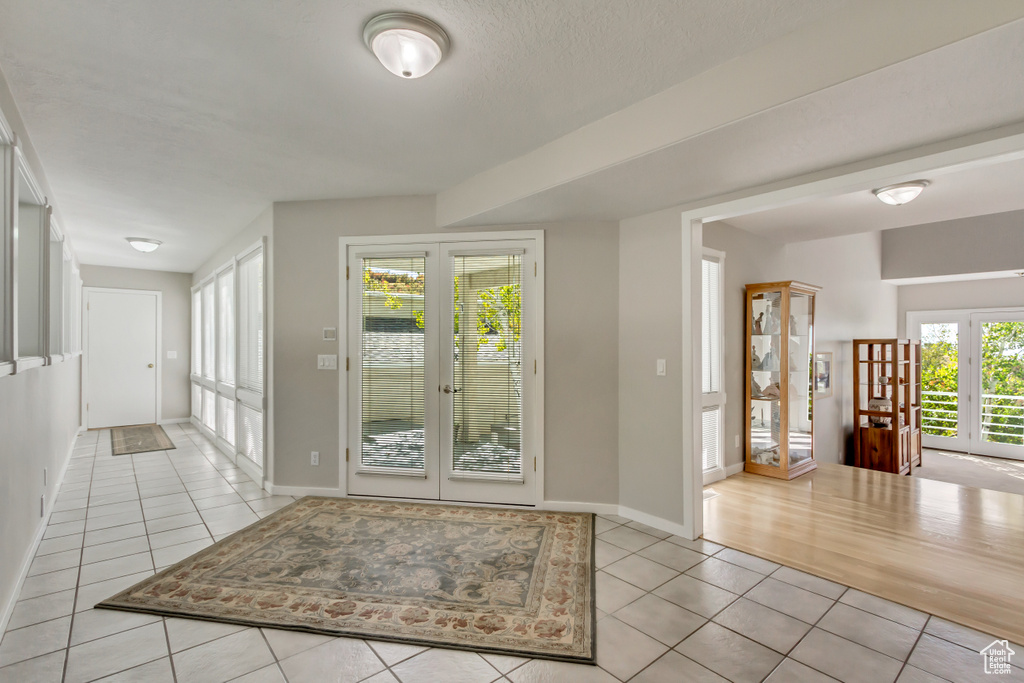 Tiled foyer featuring french doors