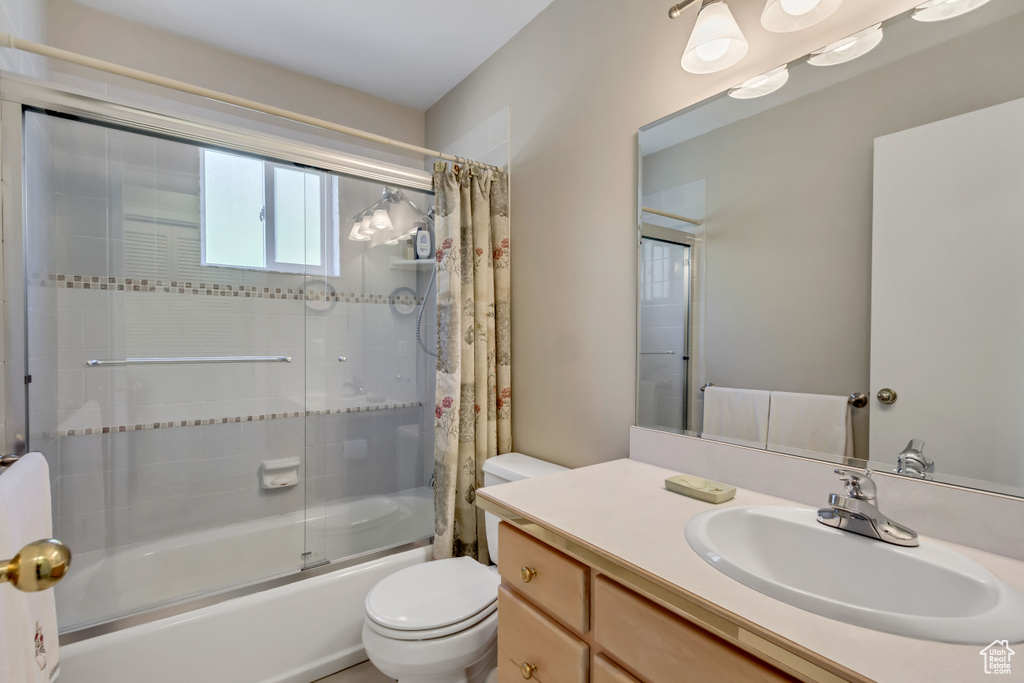 Full bathroom with shower / bath combo, vanity, and toilet