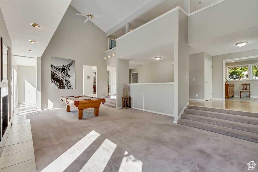 Interior space featuring ceiling fan, light carpet, pool table, and high vaulted ceiling