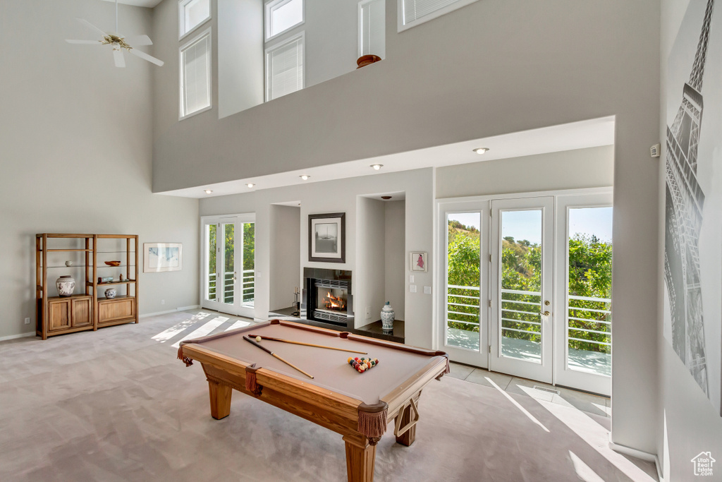 Playroom with light carpet, a towering ceiling, ceiling fan, and billiards