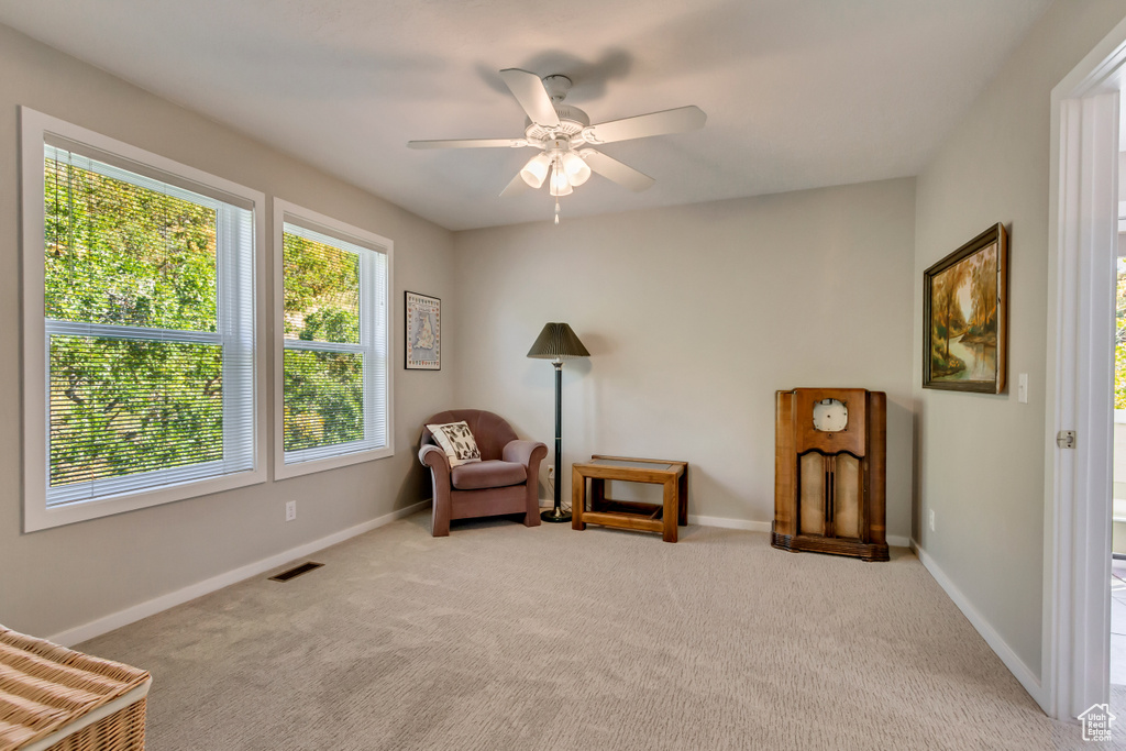 Sitting room featuring light carpet and ceiling fan