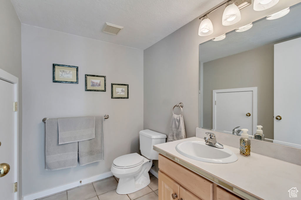 Bathroom with tile patterned flooring, vanity, and toilet