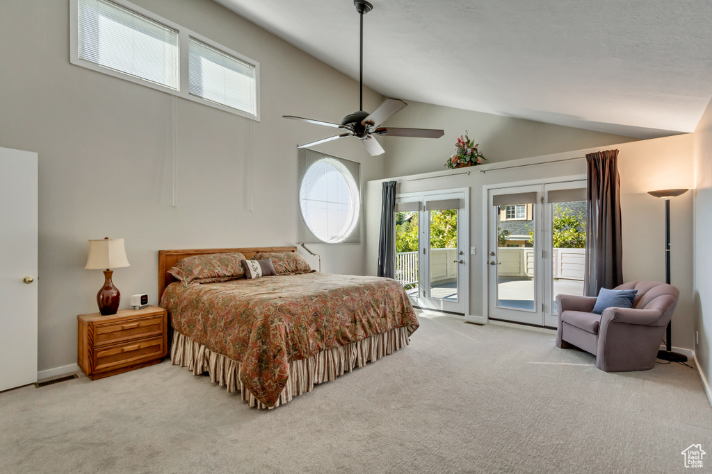 Bedroom featuring ceiling fan, light colored carpet, access to exterior, and high vaulted ceiling