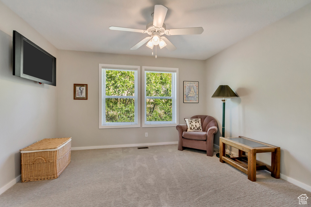 Sitting room with ceiling fan and light colored carpet