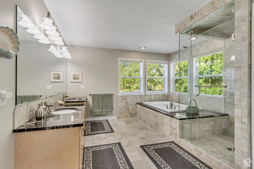 Bathroom with shower with separate bathtub, tile patterned floors, a textured ceiling, and vanity