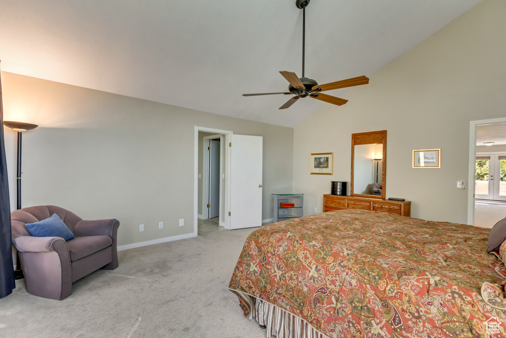 Bedroom with ceiling fan, light carpet, and high vaulted ceiling