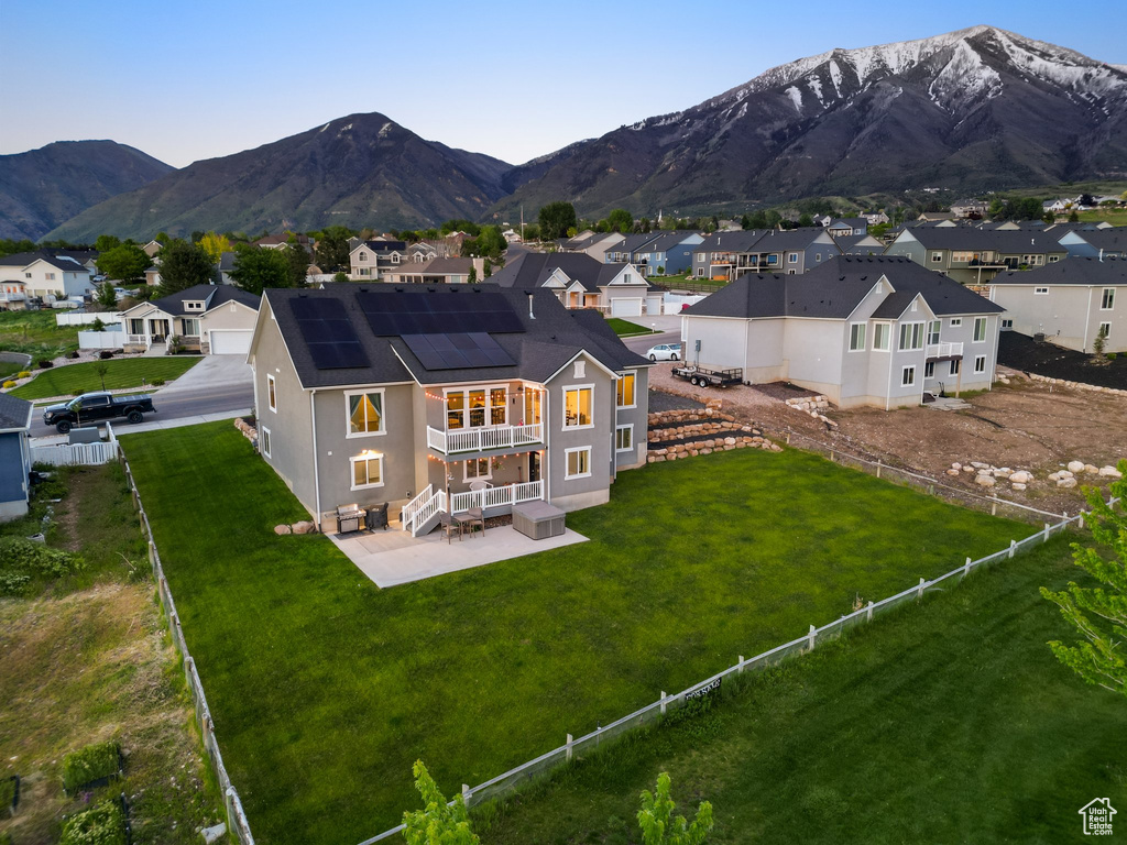Rear view of house with a patio, a residential view, a mountain view, and solar panels