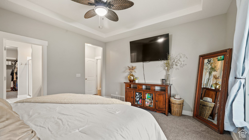 Bedroom featuring carpet floors, a tray ceiling, a ceiling fan, and baseboards