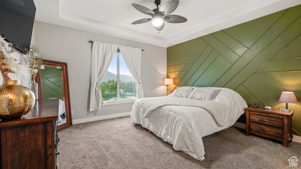 Bedroom with carpet floors, a mountain view, baseboards, and a tray ceiling