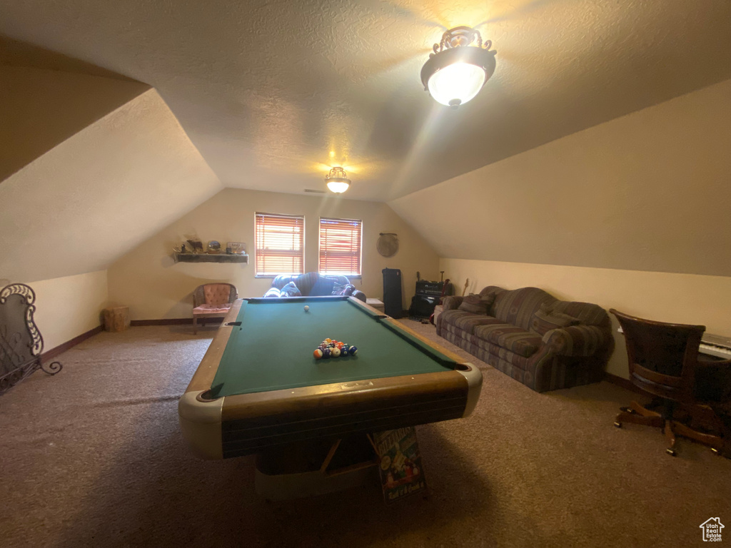 Recreation room featuring carpet, vaulted ceiling, a textured ceiling, and billiards