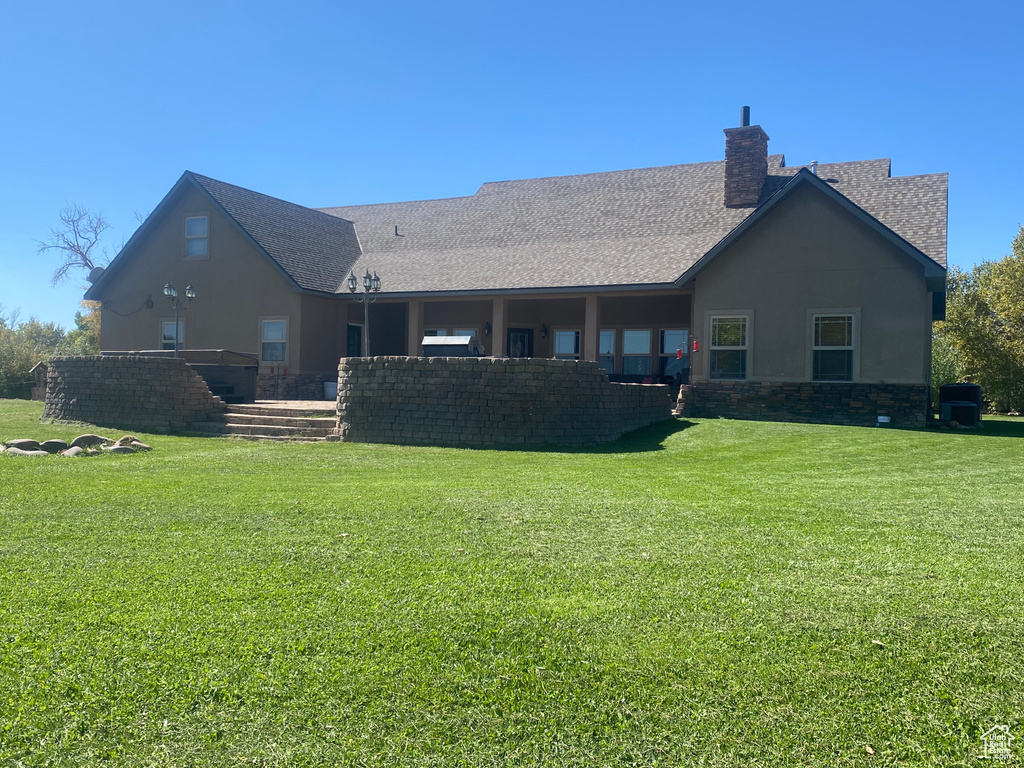 Rear view of property with a lawn