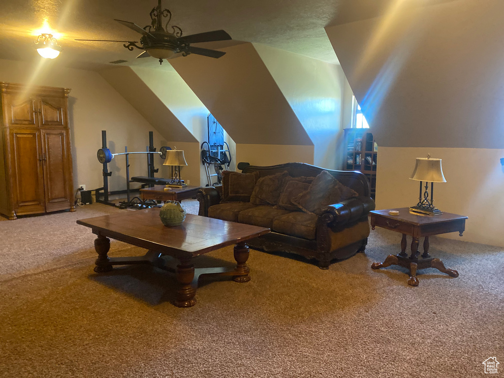 Carpeted living room with vaulted ceiling and ceiling fan