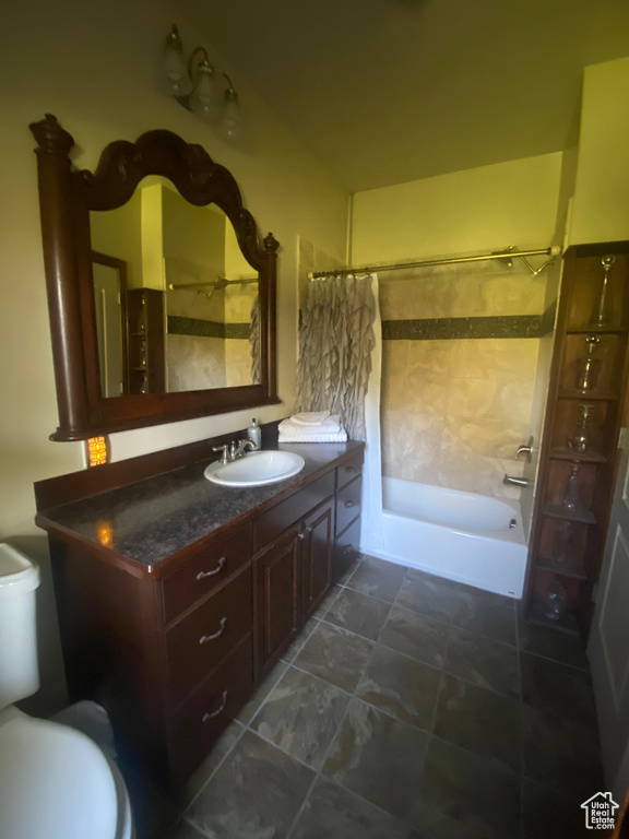 Full bathroom featuring vanity, shower / bath combo with shower curtain, and toilet