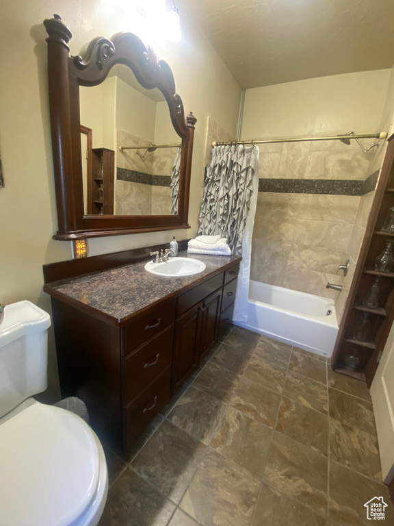 Full bathroom featuring shower / bath combo, vanity, and toilet