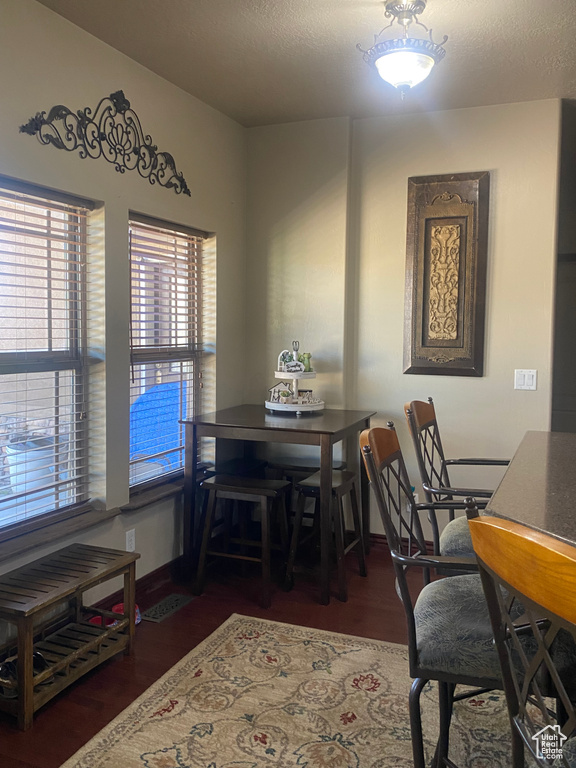 Dining space with dark wood-type flooring