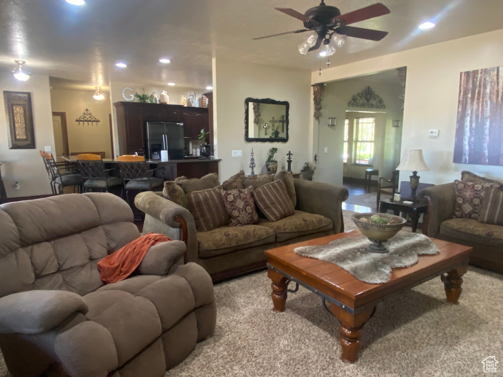 Living room with ceiling fan and light colored carpet