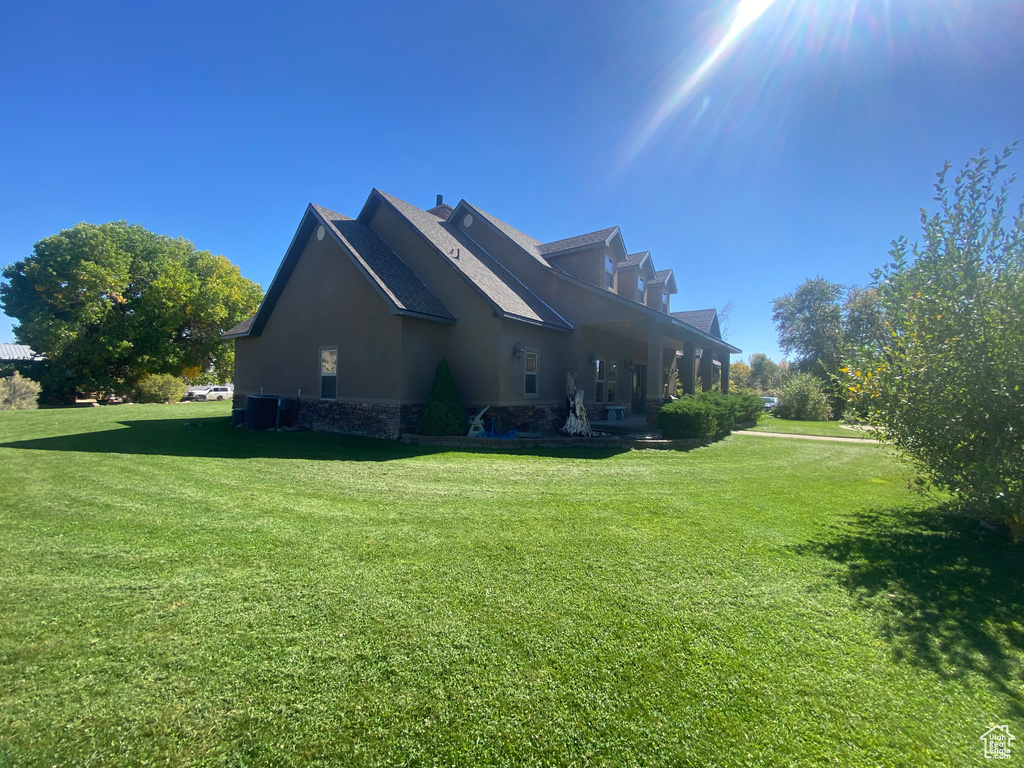 View of side of home featuring a yard