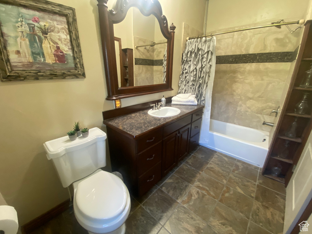 Full bathroom featuring shower / bath combo, vanity, and toilet