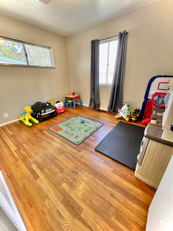 Workout room featuring a textured ceiling and light hardwood / wood-style flooring