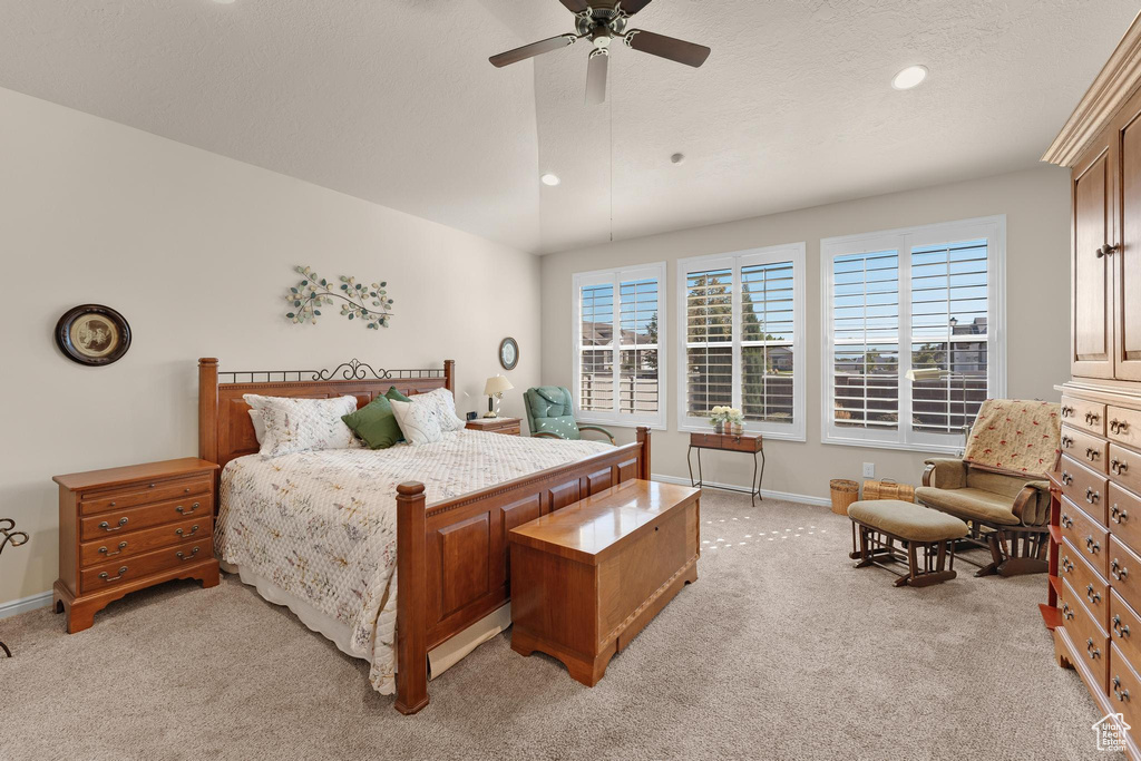 Carpeted bedroom featuring ceiling fan and a textured ceiling