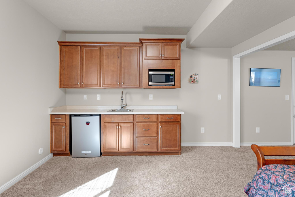 Kitchen with light carpet, stainless steel appliances, and sink