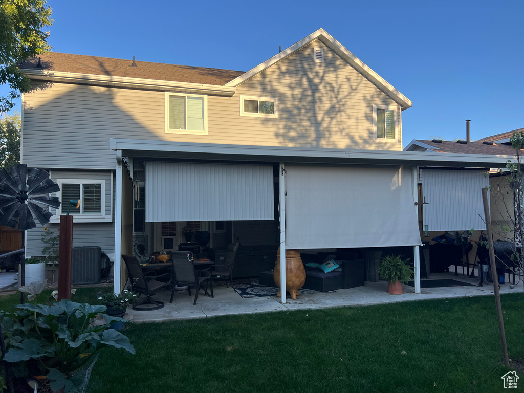 Rear view of house featuring a patio and a yard