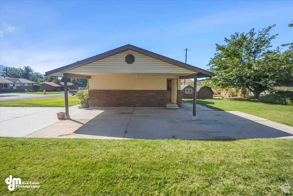 Exterior space with a front yard and a carport