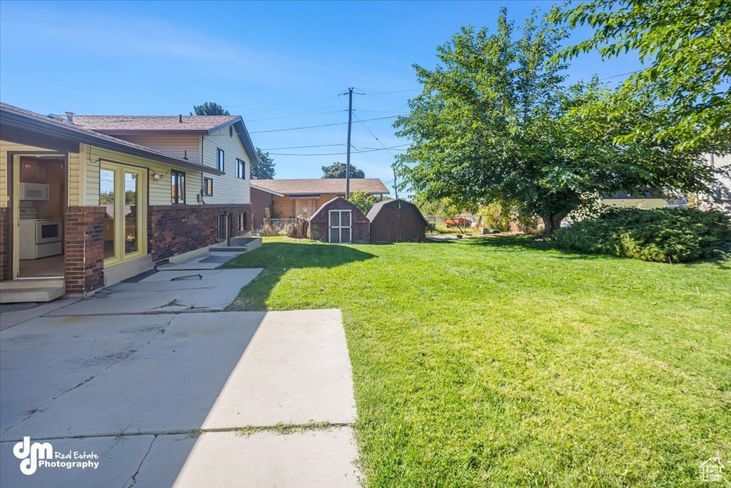 View of yard featuring a patio and a storage unit