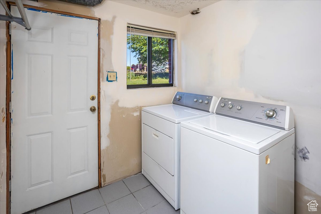 Washroom featuring light tile patterned floors and washer and clothes dryer