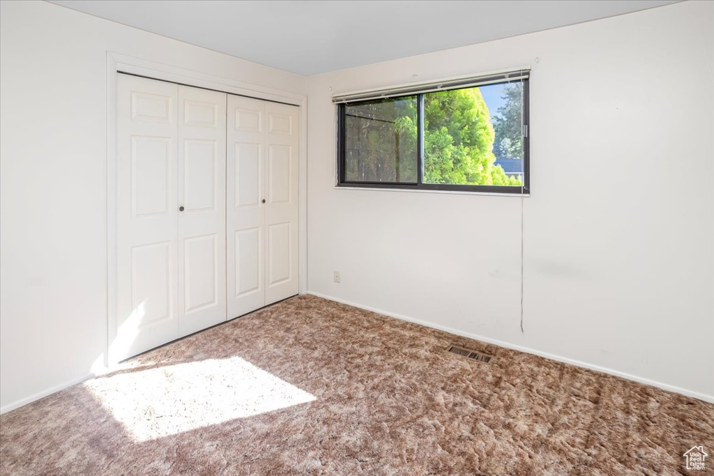 Unfurnished bedroom featuring carpet floors and a closet