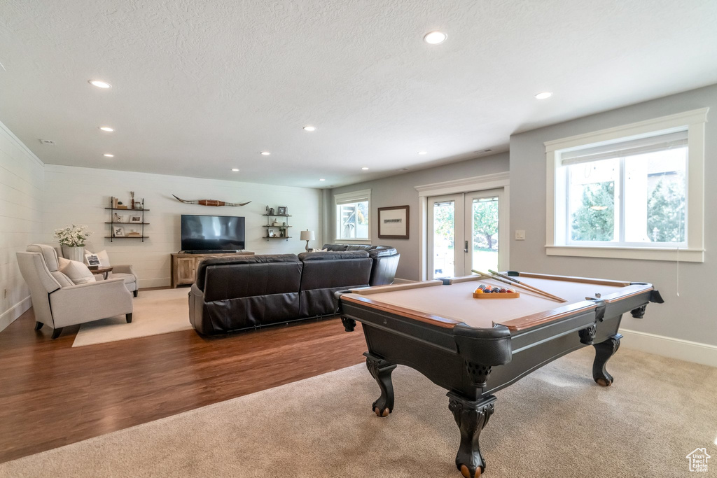 Rec room with pool table, a textured ceiling, light hardwood / wood-style floors, and french doors