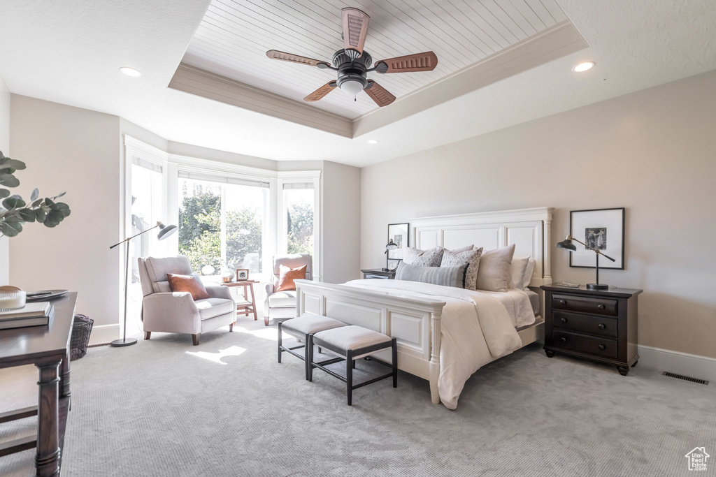 Bedroom with ceiling fan, light colored carpet, a raised ceiling, and wood ceiling