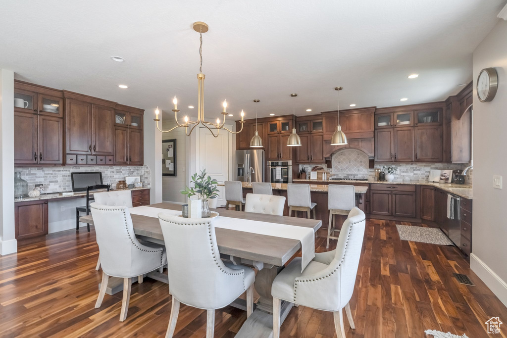 Dining room featuring an inviting chandelier, dark wood-type flooring, and sink