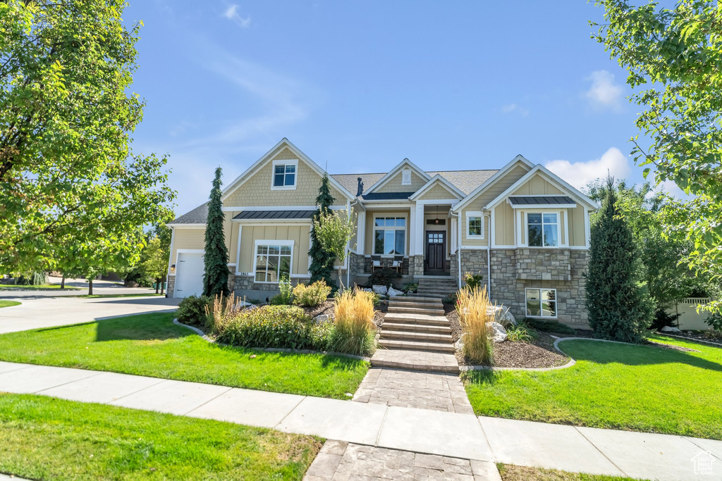 Craftsman-style house featuring a garage and a front yard