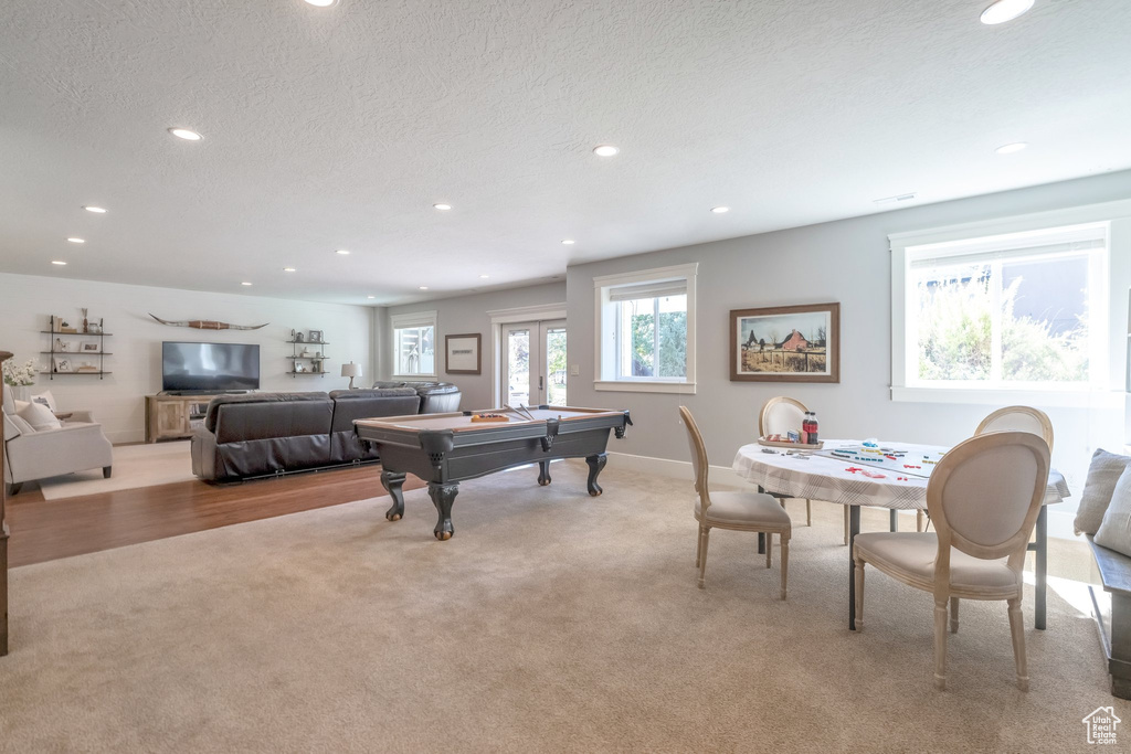 Game room featuring light carpet, pool table, and a textured ceiling