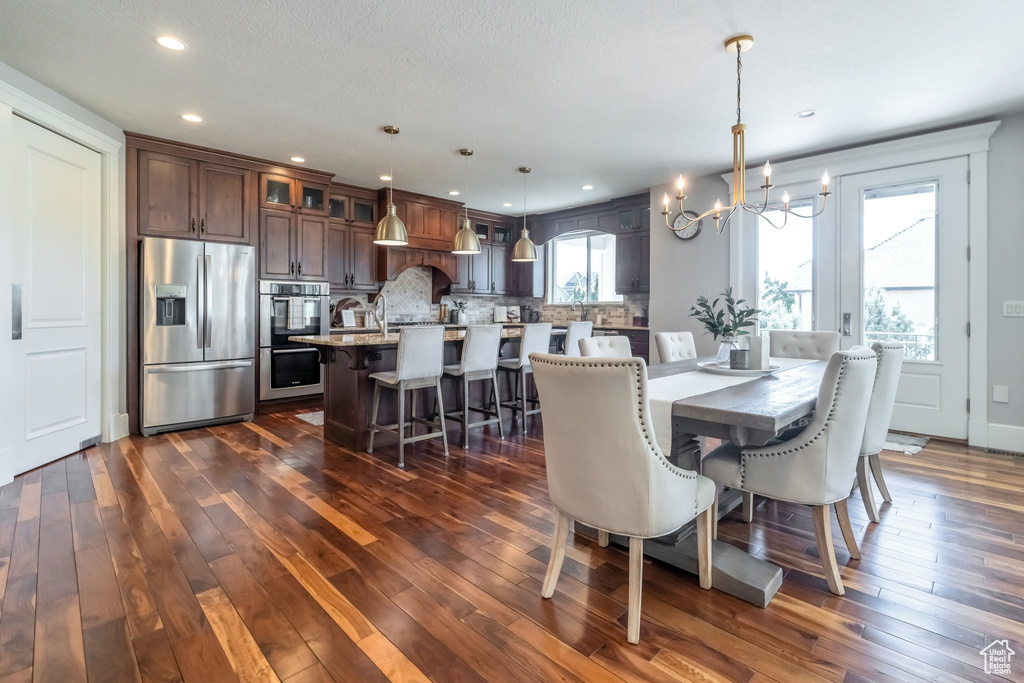 Dining room featuring dark wood-type flooring and a chandelier