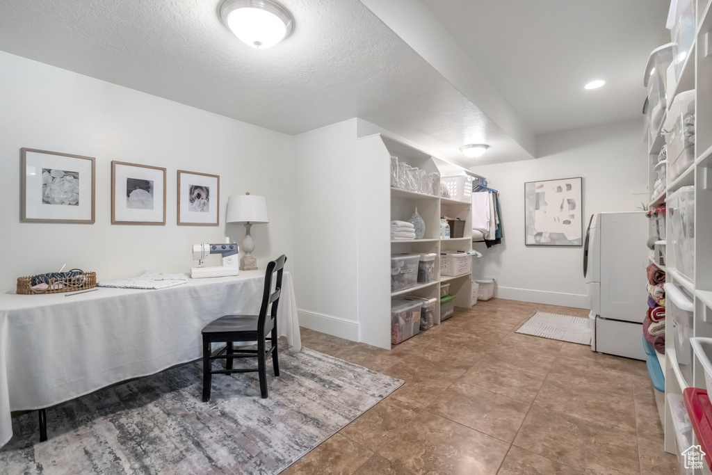 Kitchen featuring a textured ceiling, light tile patterned floors, and washer / dryer